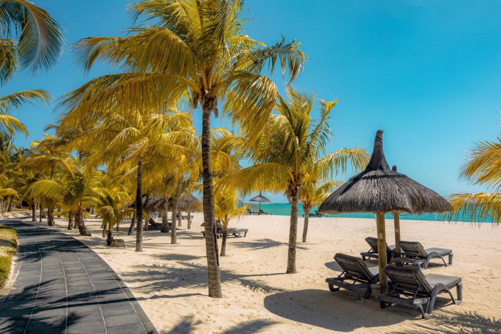 Coconut palms and a thatched parasol on a Mauritian beach