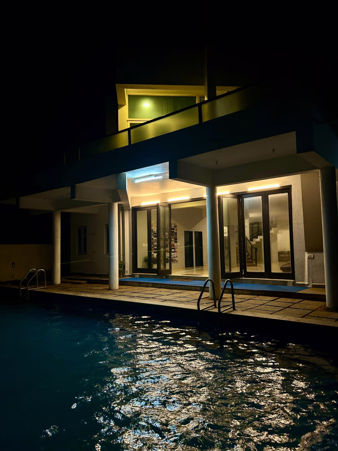 Villa and pool lit from within after dark
