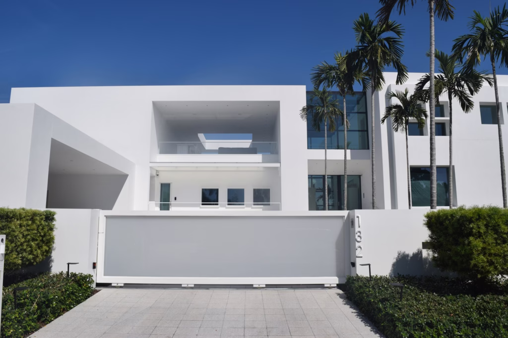 White gated entrance with palms behind